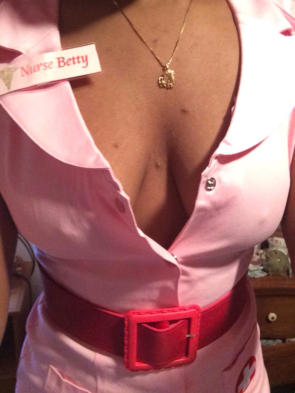Cara in a pink and red sexy nurse costume that has a name tag that says nurse Betty in post titled Pet Hold