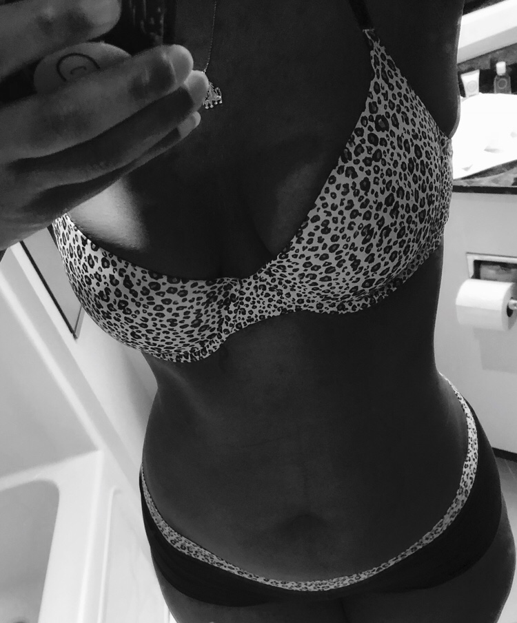 Cara in a black and white photo, wearing leopard print bar and panties with leopard spots on the band in post titled Big Cat Diary 