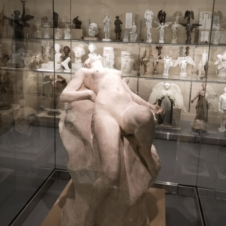 A marble statue of a naked woman lying back 