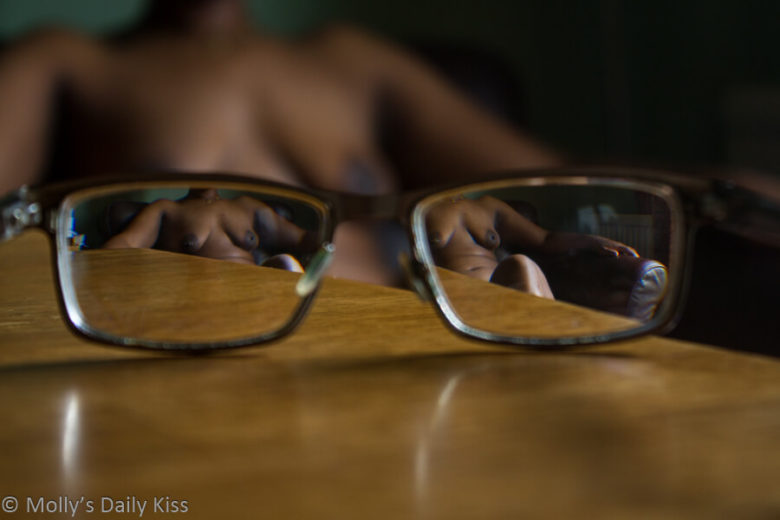 A shot through a pair of glasses with Cara naked in both lenses